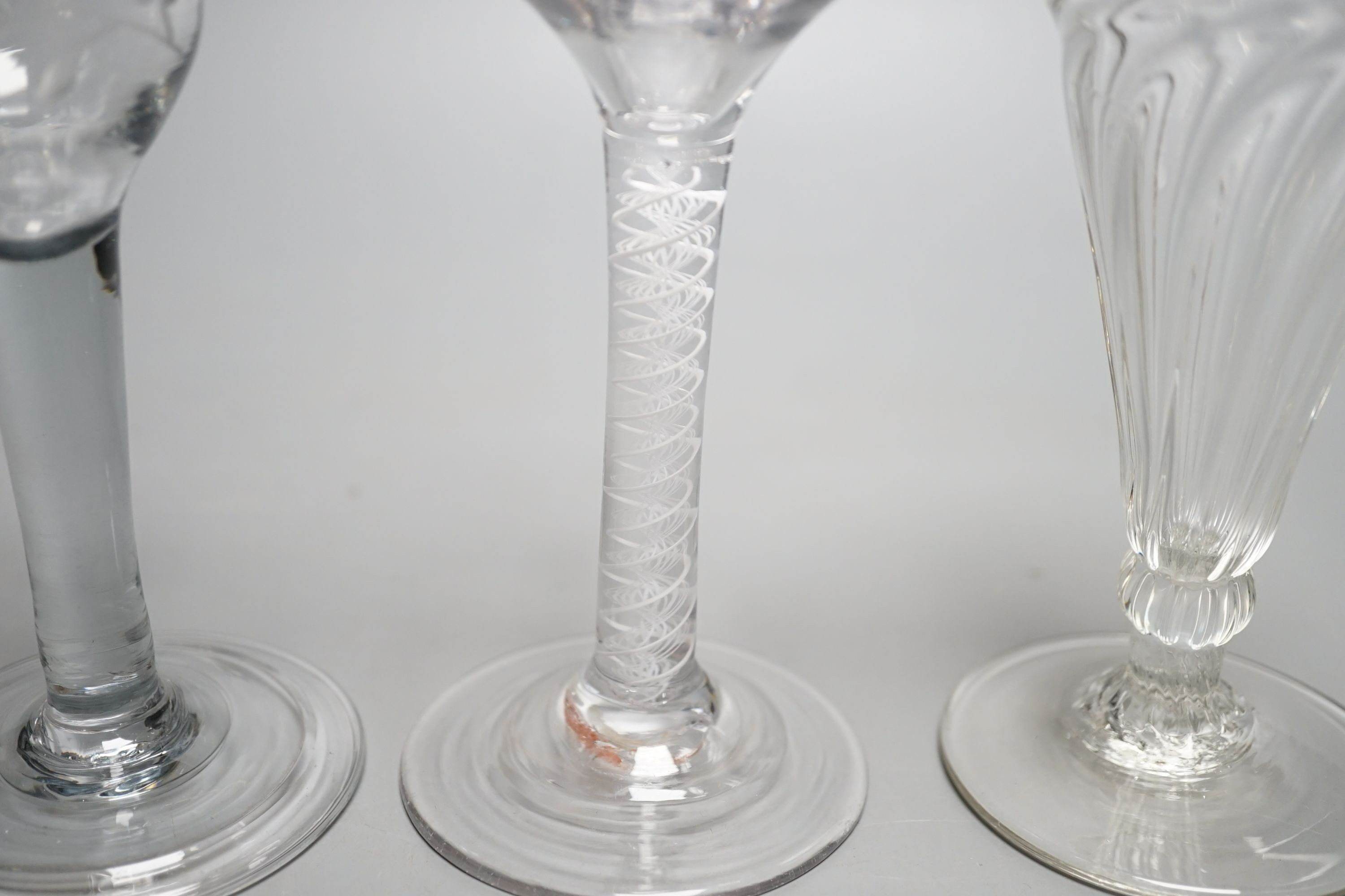 A George III opaque twist stem cordial glass, a George II cordial glass with folded foot and a wrythen twist ale glass (3) - tallest 15cm